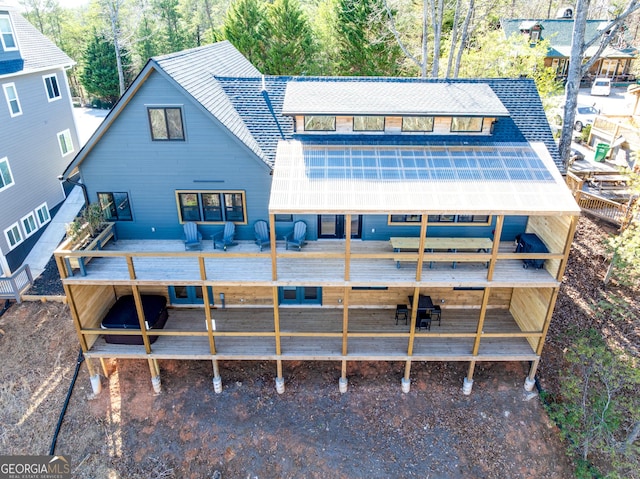 back of property featuring roof with shingles and a wooden deck