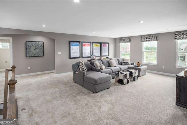 living room featuring recessed lighting, baseboards, and light colored carpet