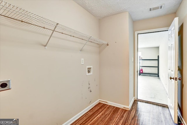 laundry area with wood finished floors, visible vents, laundry area, electric dryer hookup, and washer hookup