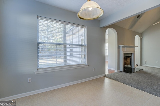 unfurnished living room featuring arched walkways, a fireplace with raised hearth, lofted ceiling with beams, and baseboards