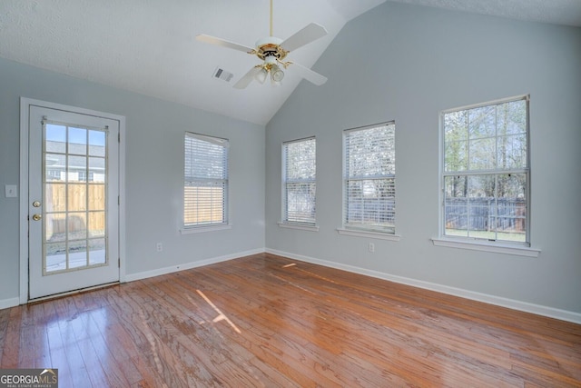 unfurnished room with visible vents, baseboards, a healthy amount of sunlight, and hardwood / wood-style floors