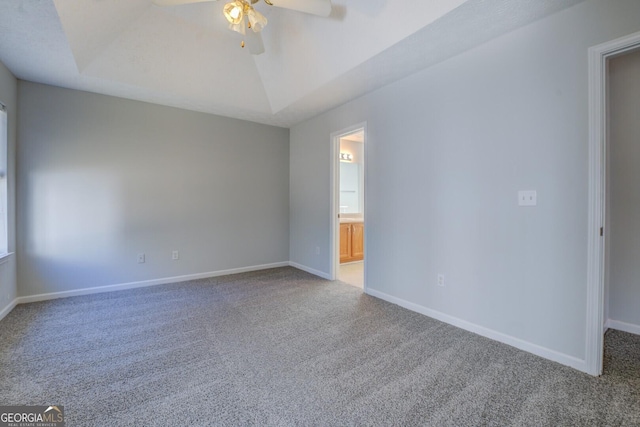 carpeted spare room featuring lofted ceiling, a ceiling fan, and baseboards