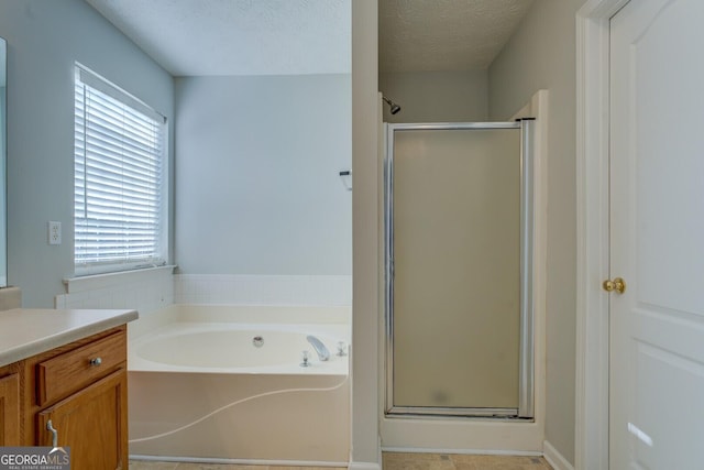 bathroom with vanity, a bath, a shower stall, and a textured ceiling