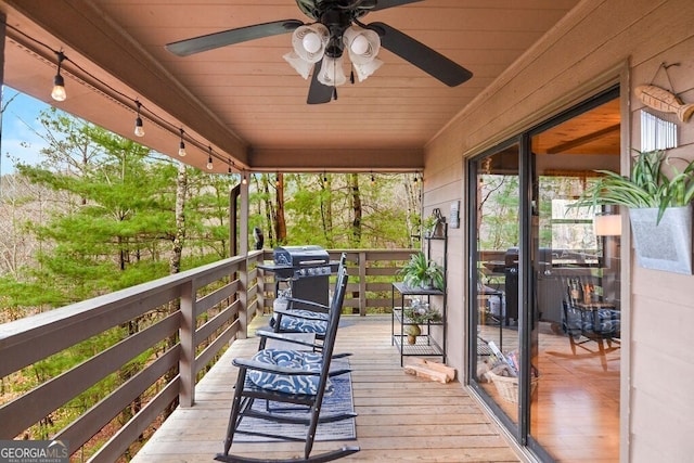 wooden deck with grilling area and a ceiling fan