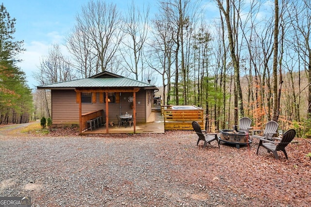 exterior space featuring a jacuzzi and a fire pit