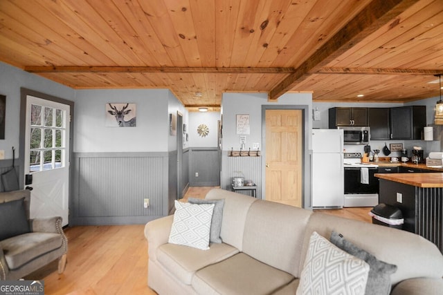 living room with wooden ceiling, light wood-style flooring, beamed ceiling, and a wainscoted wall