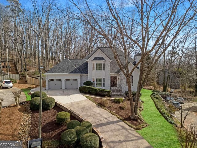 view of front of home featuring an attached garage, roof with shingles, driveway, and fence