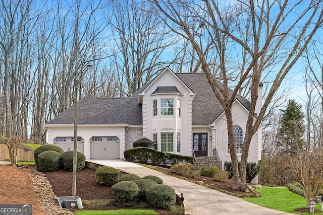 french country inspired facade with stucco siding, a garage, driveway, and a shingled roof