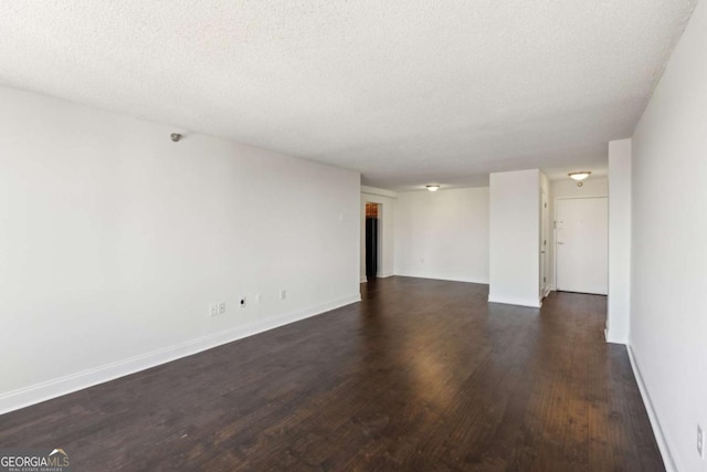 empty room featuring baseboards, dark wood-style flooring, and a textured ceiling