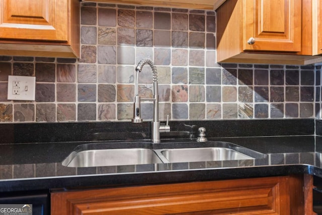 kitchen with brown cabinets, a sink, dark countertops, tasteful backsplash, and dishwasher