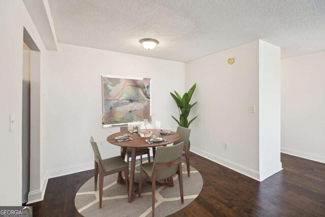 dining room featuring wood finished floors, baseboards, and a textured ceiling