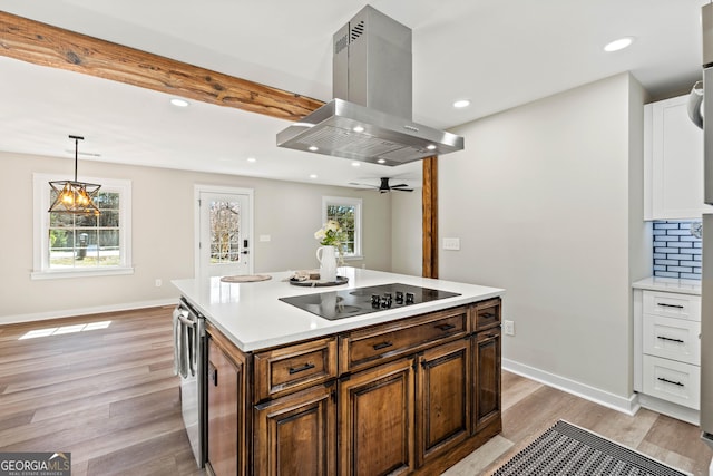 kitchen featuring island exhaust hood, baseboards, black electric stovetop, and light wood-style flooring