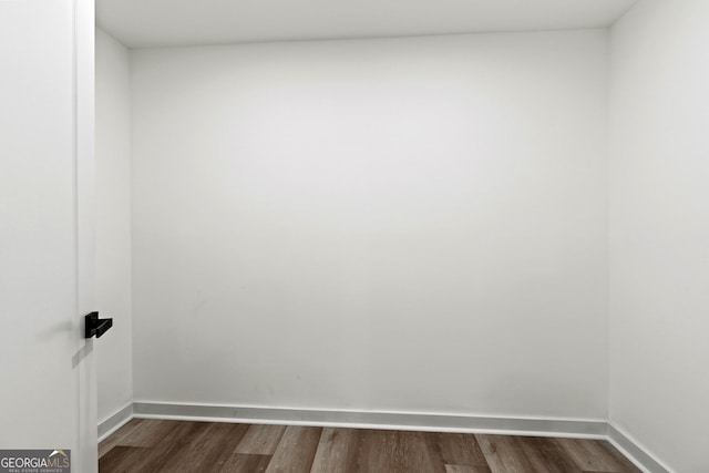 spare room featuring dark wood finished floors and baseboards