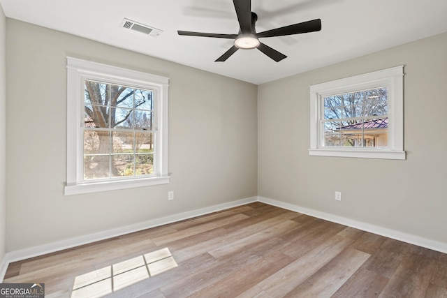 unfurnished room with visible vents, ceiling fan, baseboards, and wood finished floors