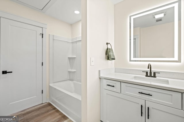 full bath featuring visible vents, shower / washtub combination, wood finished floors, and vanity