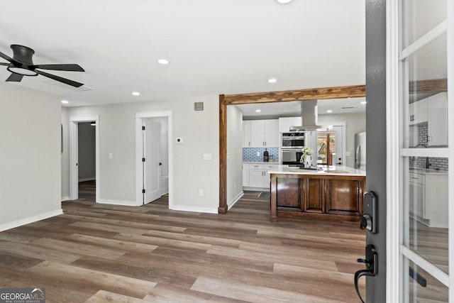 interior space with baseboards, recessed lighting, a ceiling fan, and light wood-style floors