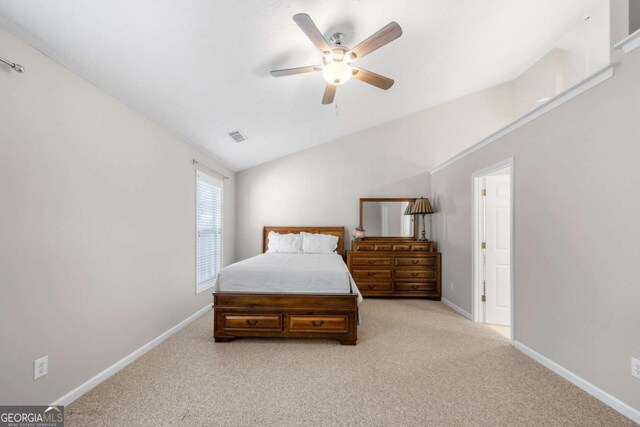 bedroom with visible vents, light carpet, baseboards, ceiling fan, and vaulted ceiling