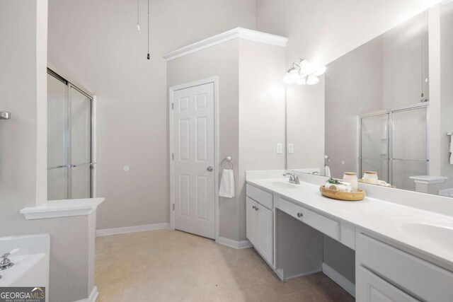 bathroom with a sink, baseboards, a stall shower, and double vanity