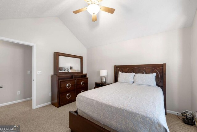 carpeted bedroom featuring baseboards, lofted ceiling, and a ceiling fan