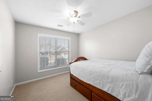 bedroom with visible vents, carpet floors, baseboards, and a ceiling fan