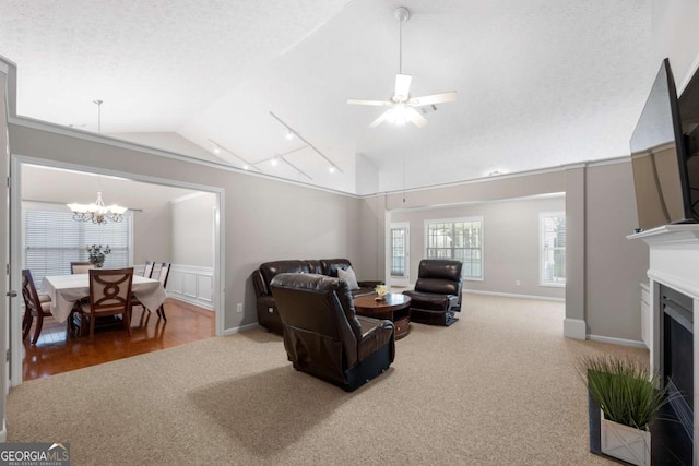 living room with carpet flooring, a fireplace, a textured ceiling, and vaulted ceiling