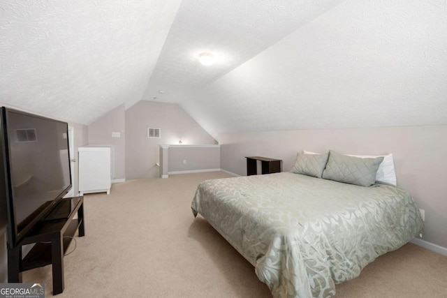 bedroom with baseboards, visible vents, vaulted ceiling, a textured ceiling, and light colored carpet