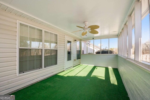 unfurnished sunroom featuring ceiling fan