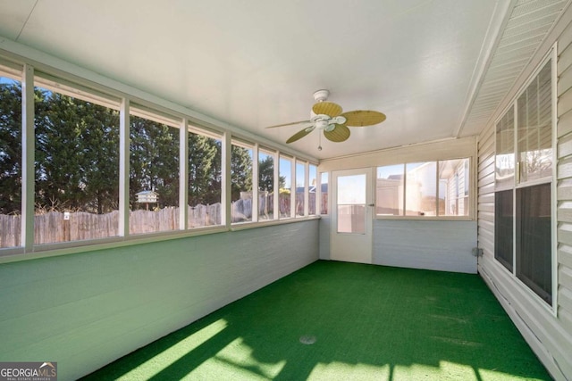 unfurnished sunroom featuring a ceiling fan