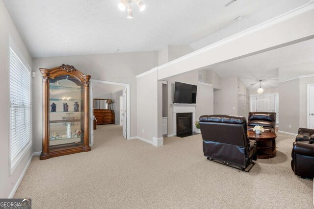 living room with a fireplace with flush hearth, baseboards, carpet, and vaulted ceiling