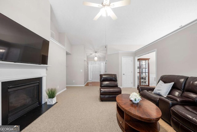 carpeted living area featuring baseboards, a fireplace with flush hearth, ceiling fan, and vaulted ceiling