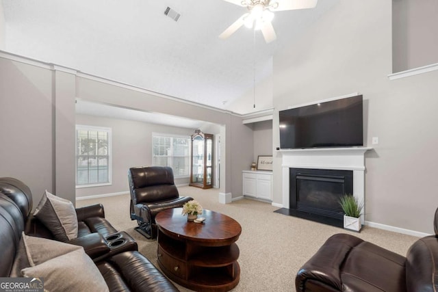 living area featuring a fireplace with flush hearth, light colored carpet, visible vents, and baseboards