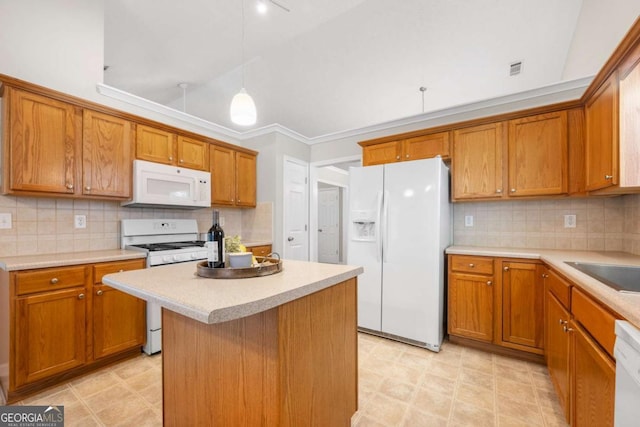 kitchen with white appliances, brown cabinetry, a kitchen island, light countertops, and tasteful backsplash