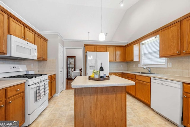 kitchen featuring white appliances, vaulted ceiling, brown cabinets, and a sink