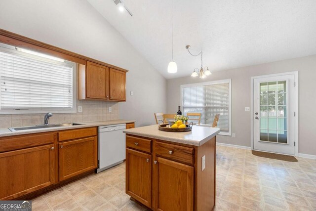 kitchen featuring decorative light fixtures, dishwasher, light countertops, brown cabinetry, and a sink