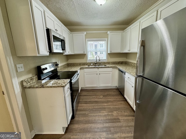 kitchen with a sink, dark wood-type flooring, white cabinets, and stainless steel appliances