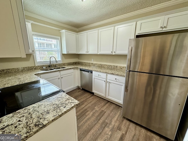 kitchen with dark wood-type flooring, stainless steel appliances, white cabinets, a textured ceiling, and a sink