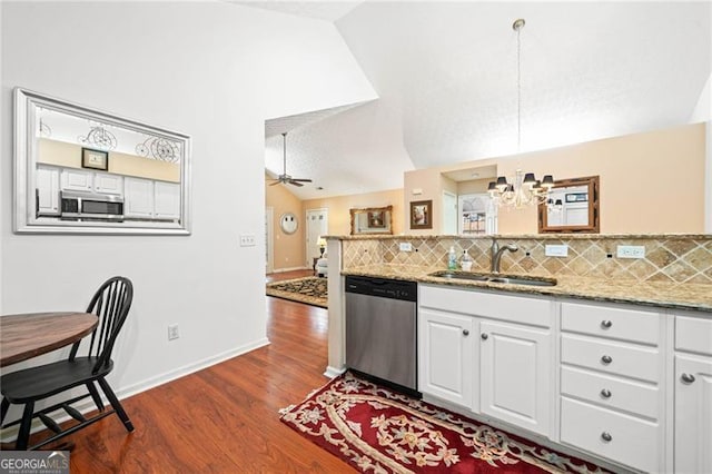 kitchen featuring lofted ceiling, a sink, stainless steel appliances, white cabinetry, and tasteful backsplash