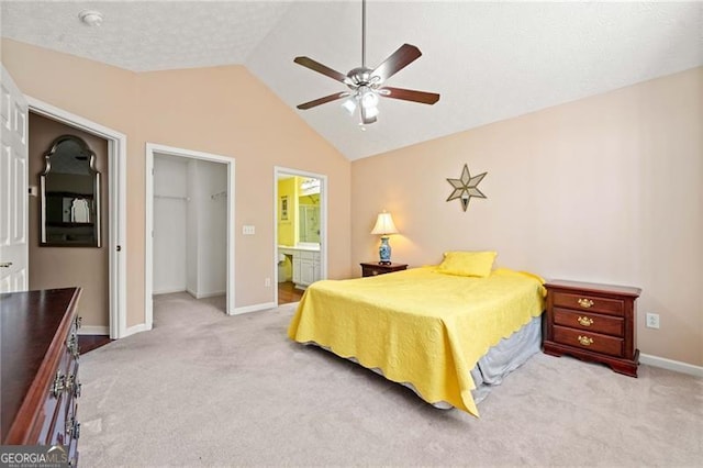 bedroom with a walk in closet, lofted ceiling, a closet, and carpet floors