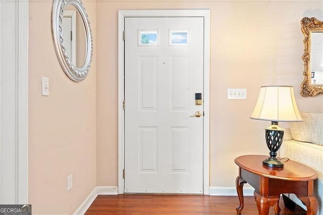 foyer entrance with baseboards and wood finished floors