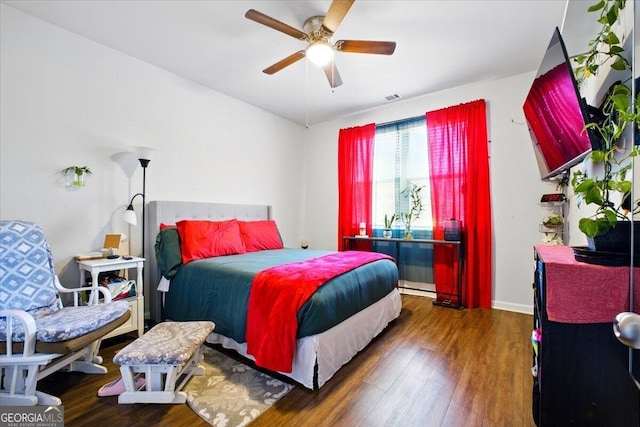 bedroom featuring a ceiling fan, wood finished floors, and visible vents