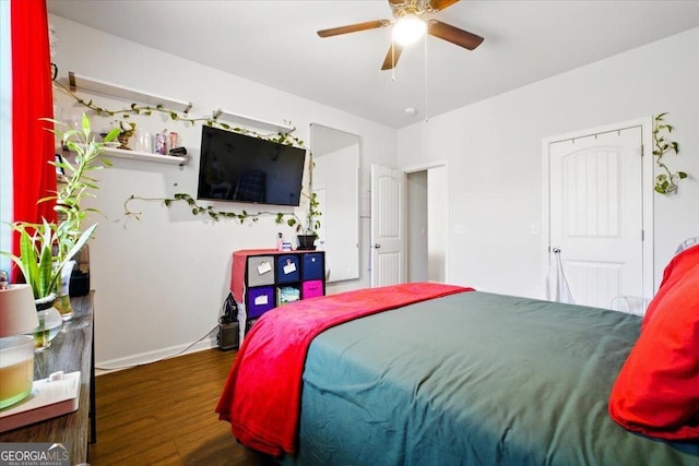 bedroom with a ceiling fan, wood finished floors, and baseboards