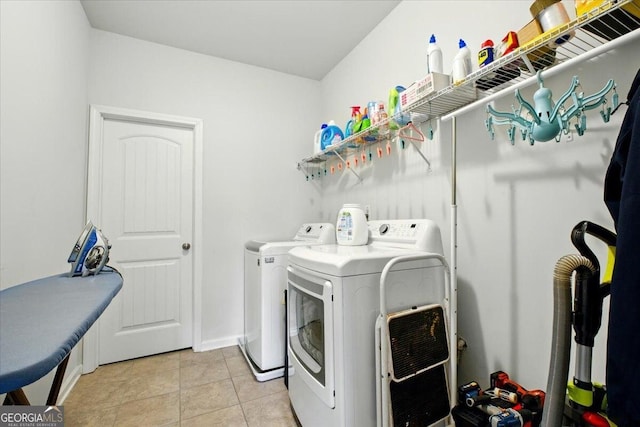 clothes washing area with washer and clothes dryer, laundry area, and light tile patterned flooring