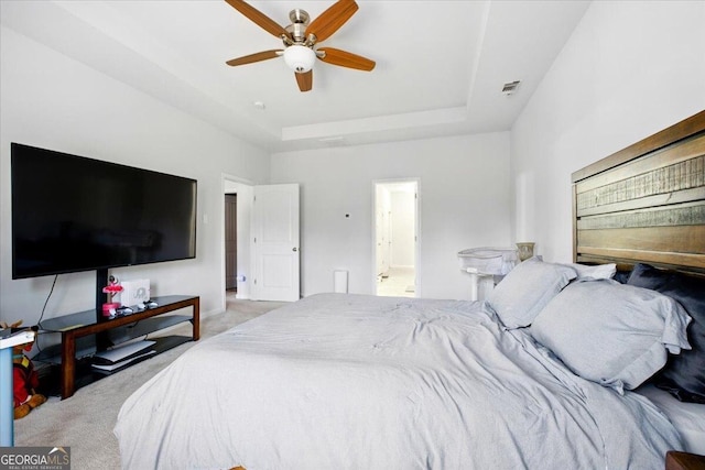 bedroom with visible vents, a ceiling fan, carpet, and a tray ceiling