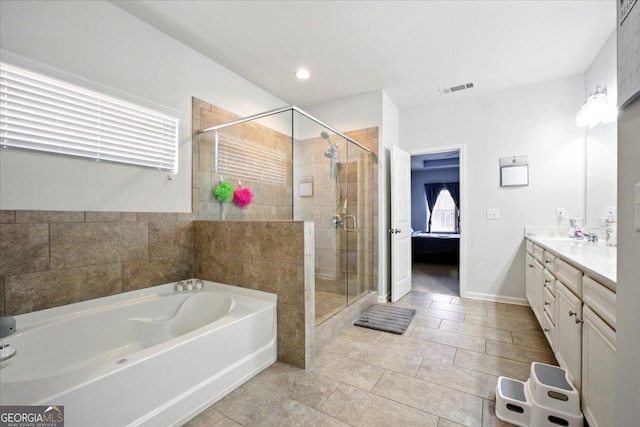 bathroom with double vanity, a bath, visible vents, and a shower stall