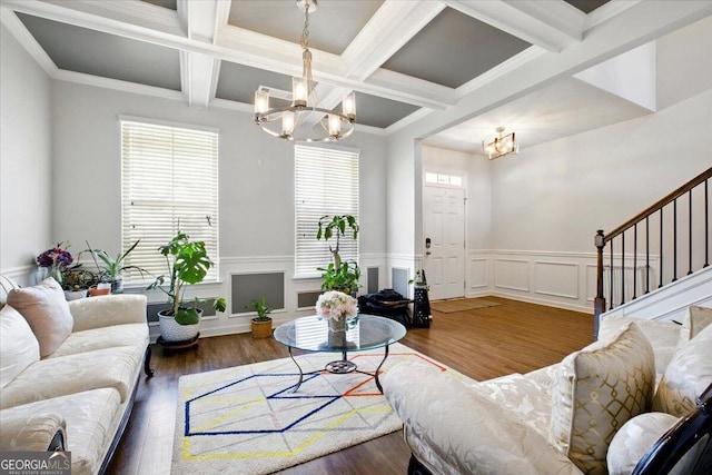 living room with beamed ceiling, an inviting chandelier, wood finished floors, and stairs