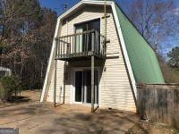 rear view of property featuring a gambrel roof