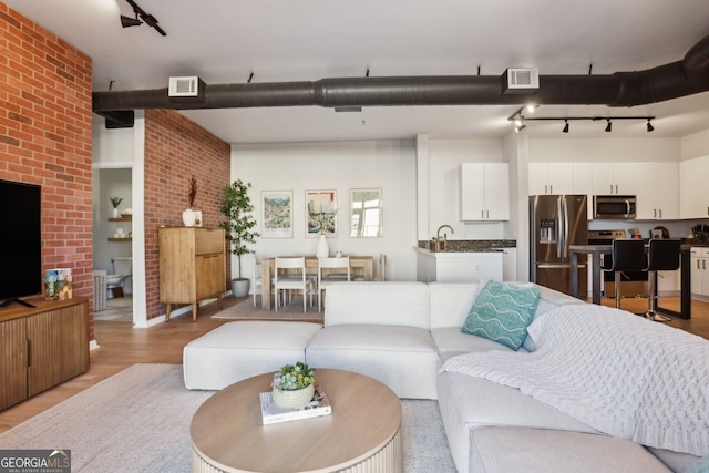 living room featuring light wood-style floors and visible vents