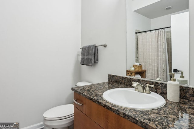 bathroom with vanity, a shower with shower curtain, and toilet