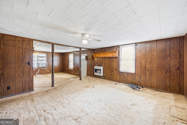 basement featuring heating unit, carpet flooring, and wood walls