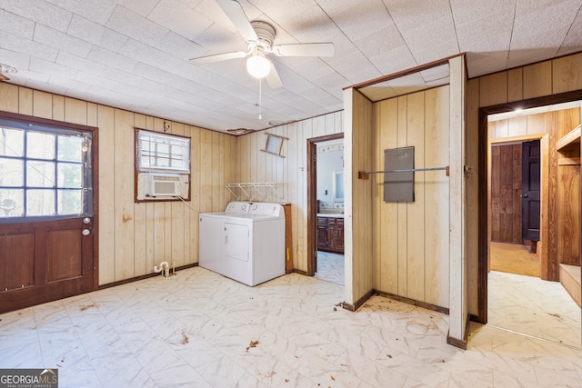 laundry area featuring wood walls, washing machine and dryer, cooling unit, marble finish floor, and a ceiling fan